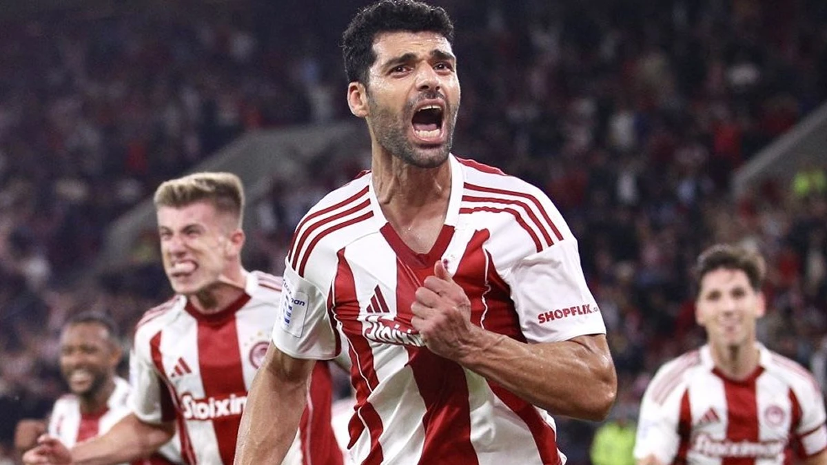 Οι παίκτες του Ολυμπιακού πανηγυρίζουν σε ευρωπαϊκό αγώνα, με φόντο τη μάχη για το Champions League.