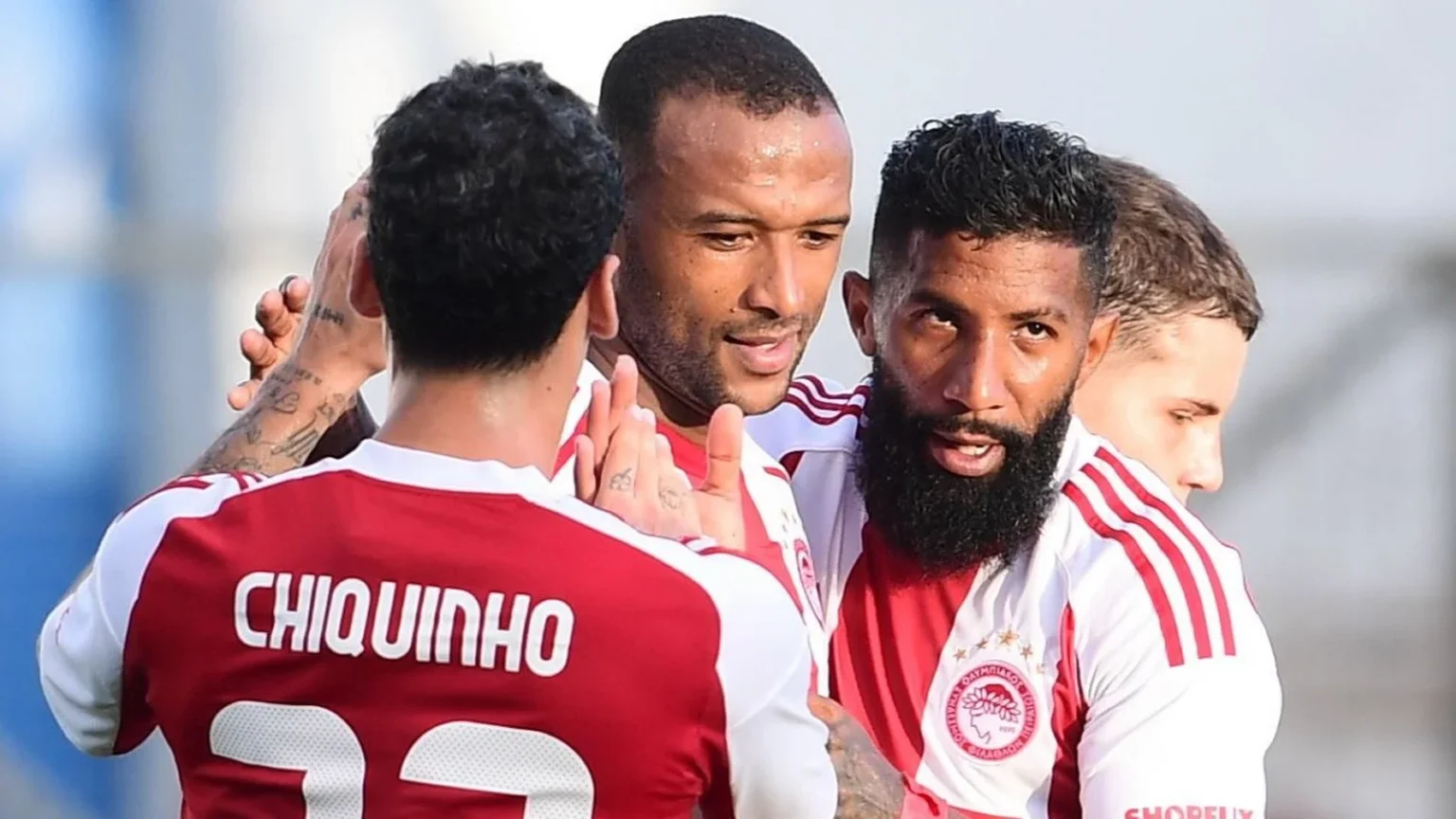 Οι παίκτες του Ολυμπιακού πανηγυρίζουν γκολ σε αγώνα πρωταθλήματος.