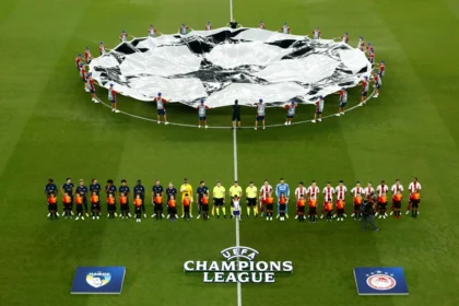 Παίκτες του Ολυμπιακού ευρωπαϊκό αγώνα, με φόντο το πανο του Champions League.