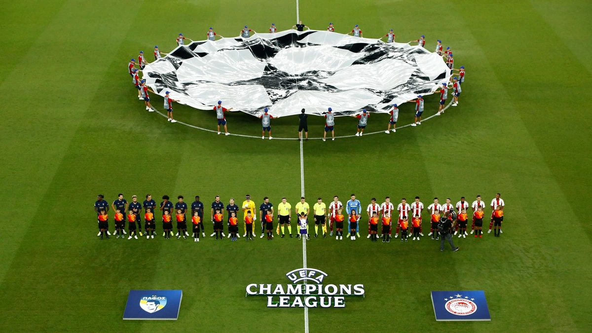 Παίκτες του Ολυμπιακού ευρωπαϊκό αγώνα, με φόντο το πανο του Champions League.