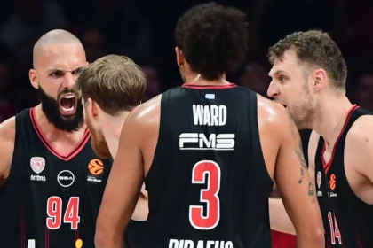 Οι παίκτες του Ολυμπιακού πανηγυρίζουν σε αγώνα Euroleague στο ΣΕΦ, σε στιγμή που τονίζει την κυριαρχία της ομάδας.