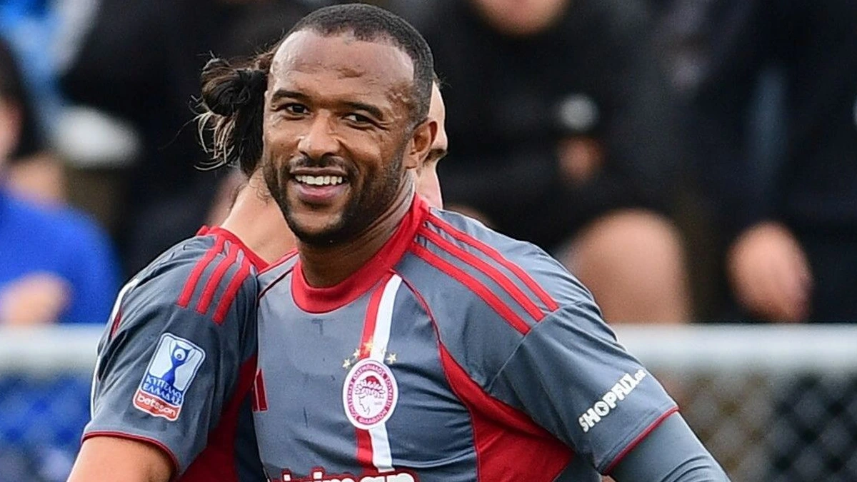 Παίκτες του Ολυμπιακού πατούν σε πλαστικό χλοοτάπητα στη Σύρο