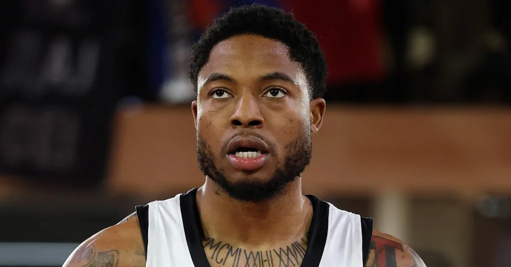 Ο Ταϊρίκ Τζόουνς στη φανέλα της Παρτιζάν, στο φόντο το σήμα του Ολυμπιακού