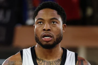 Ο Ταϊρίκ Τζόουνς στη φανέλα της Παρτιζάν, στο φόντο το σήμα του Ολυμπιακού