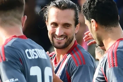 Ο Γιουσούφ Γιαζίτσι πανηγυρίζει γκολ με τη φανέλα του Ολυμπιακού