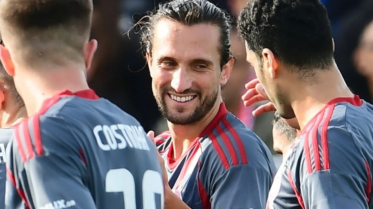 Ο Γιουσούφ Γιαζίτσι πανηγυρίζει γκολ με τη φανέλα του Ολυμπιακού