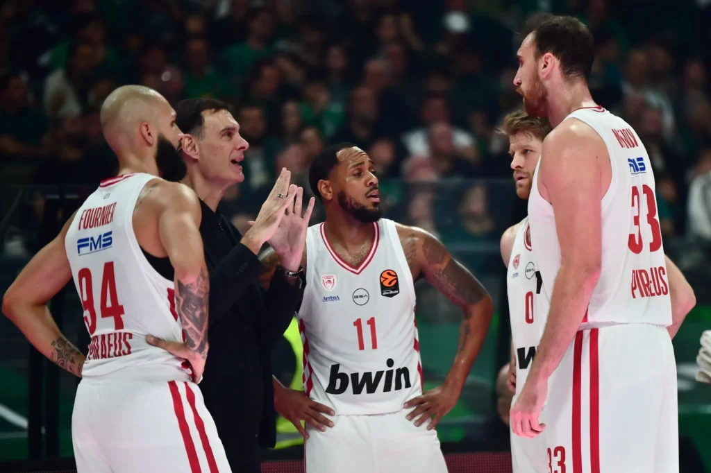 Ο Μόντε Μόρις με τη φανέλα του Ολυμπιακού ακούει τις οδηγίες του προπονητή του