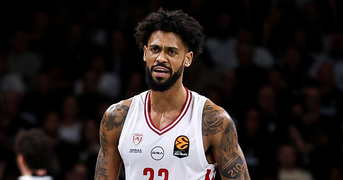 Ο Τάιλερ Ντόρσεϊ στον αέρα με σώμα εκτός ισορροπίας σουτάρει μπροστά σε δύο παίκτες του Παναθηναϊκού ενώ το χρονόμετρο δείχνει το τέλος.