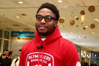 Ο Ταϊρίκ Τζόουνς χαμογελαστός ανάμεσα σε οπαδούς του Ολυμπιακού στο αεροδρόμιο