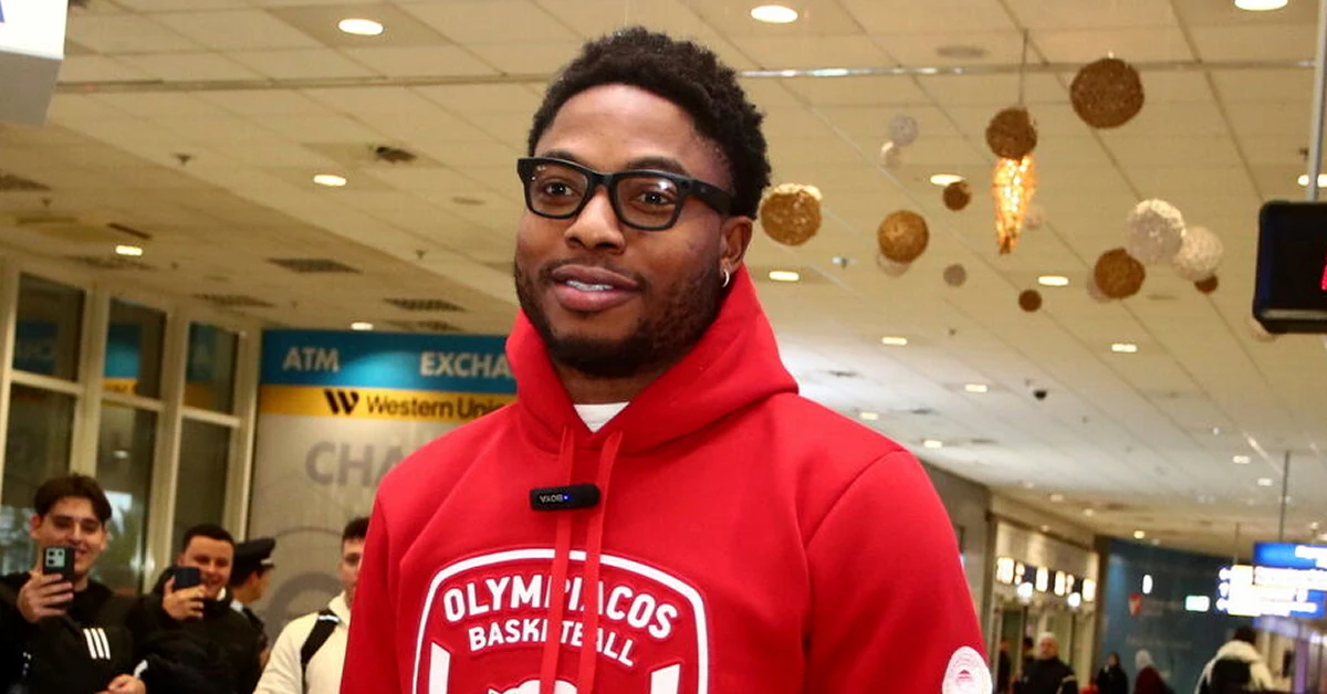 Ο Ταϊρίκ Τζόουνς χαμογελαστός ανάμεσα σε οπαδούς του Ολυμπιακού στο αεροδρόμιο