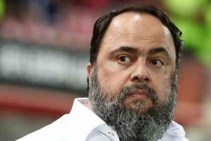 Ο Βαγγέλης Μαρινάκης πανηγυρίζει τις επιτυχίες του Ολυμπιακού με φόντο το έμβλημα των 100 χρόνων