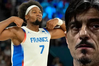 Ο Γκέρσον Γιαμπουσέλε με φανέλα του NBA ενώ ο Δημήτρης Γιαννακόπουλος κοιτάζει σκεπτικός κατά τη διάρκεια διακοπής αγώνα