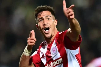 Ο Χαράλαμπος Κωστούλας πανηγυρίζει με πάθος γκολ με τη φανέλα του Ολυμπιακού.