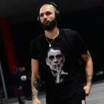 Ο Εβάν Φουρνιέ φοράει μπλουζάκι με τον Γιώργο Μπαρτζώκα να κάνει νόημα ησυχίας