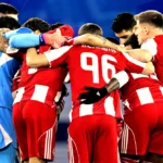 Οι ποδοσφαιριστές του Ολυμπιακού αγκαλιασμένοι πριν από αγώνα, δείχνοντας πάθος και συσπείρωση ενόψει του ντέρμπι με τον ΠΑΟΚ.