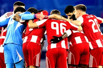 Οι ποδοσφαιριστές του Ολυμπιακού αγκαλιασμένοι πριν από αγώνα, δείχνοντας πάθος και συσπείρωση ενόψει του ντέρμπι με τον ΠΑΟΚ.