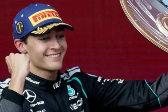 Ο Τζορτζ Ράσελ της Mercedes χαμογελάει κρατώντας το τρόπαιο του νικητή στο βάθρο του Grand Prix της Αυστραλίας
