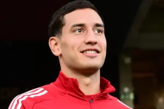 μέσος του Ολυμπιακού Σαντιάγκο Έσε με την κόκκινη προπονητική ζακέτα της ομάδας.