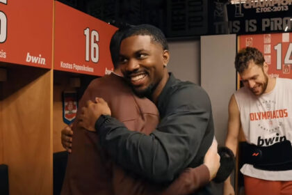 Ο Κίναν Έβανς χαμογελαστός με τα ρούχα του Ολυμπιακού κατά την ξαφνική επιστροφή του στην Ελλάδα και την ομάδα.