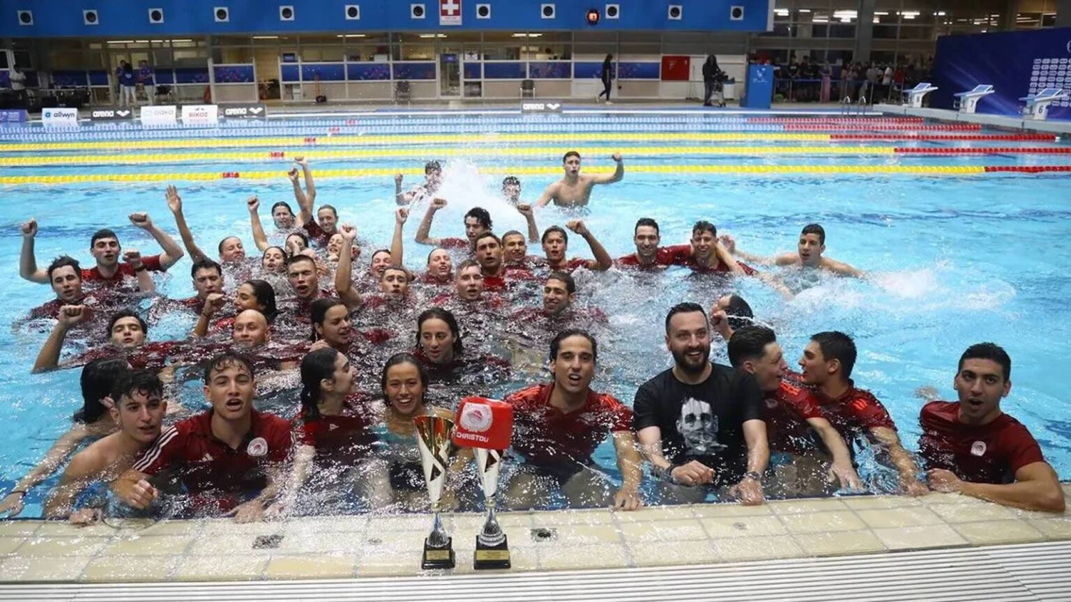 Οι κολυμβητές του Ολυμπιακού πανηγυρίζουν την κατάκτηση του 67ου Εθνικού Πρωταθλήματος στην κολύμβηση μέσα στην πισίνα.