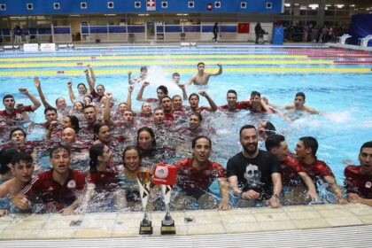 Οι κολυμβητές του Ολυμπιακού πανηγυρίζουν την κατάκτηση του 67ου Εθνικού Πρωταθλήματος στην κολύμβηση μέσα στην πισίνα.